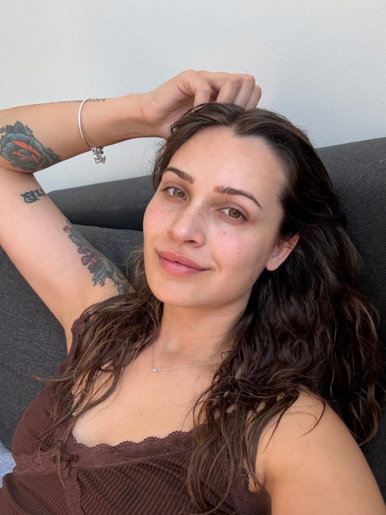 Selfie von Lena Westermann auf dem Sofa, ungeschminkt mit nassen Haaren, trägt ein braunes Top.