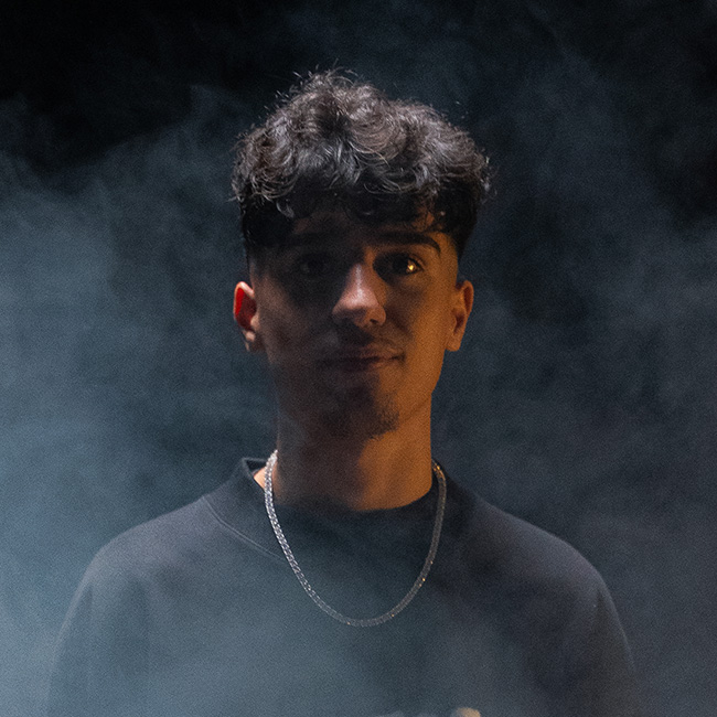 Porträt von Eldeno in dunkler Umgebung mit Nebel, direkter Blick in die Kamera.