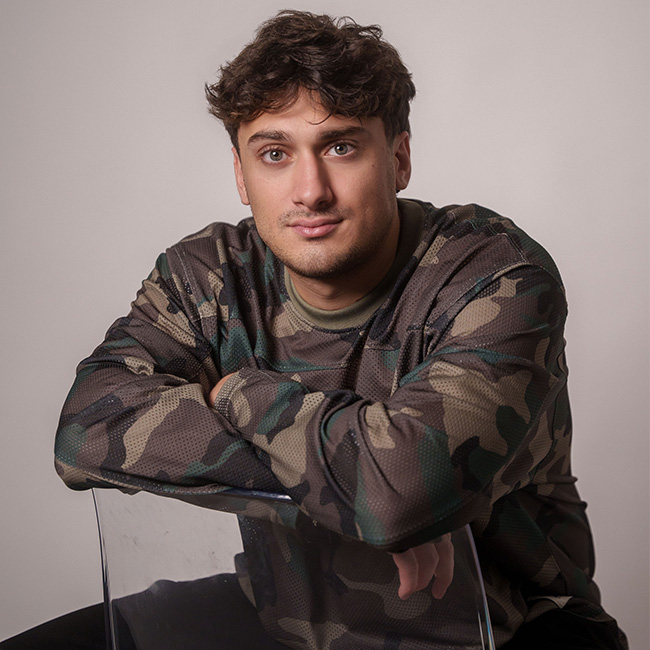 Porträt von Daniele Gieron im Camouflage-Shirt, bekannt als Datedoktor Daniele für Dating- und Beziehungscontent